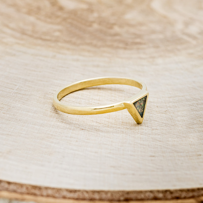 Shown here is "Mera", a triangle-style women's stacking band featuring a triangle channel filled with black fire opal on a 14K gold band, facing right. Many center stone options are available upon request.