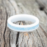 Shown here is "Perenna", a custom, handcrafted women's stacking band featuring a turquoise inlay on a white ceramic band, laying flat. Additional inlay options are available upon request.