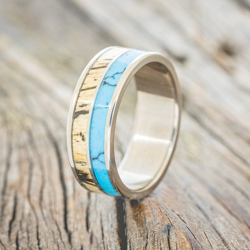 Shown here is "Dyad", a custom, handcrafted men's wedding ring featuring 2 channels with spalted maple wood and turquoise with black matrix TruStone inlays, upright facing left. Additional inlay options are available upon request.