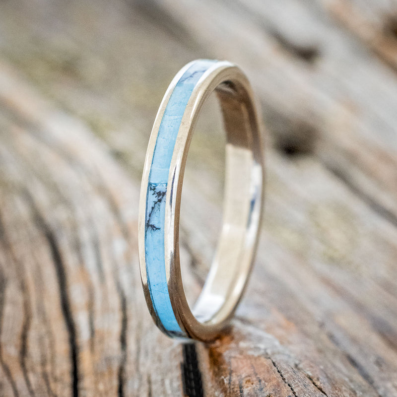 Shown here is "Eterna", a custom, handcrafted women's stacking band featuring a turquoise and black matrix TruStone inlay, upright facing left. Additional inlay options are available upon request.