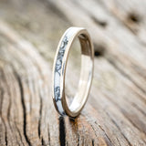 Shown here is "Eterna", a custom, handcrafted wedding ring featuring white turquoise TruStone overlay on a titanium band, upright facing left. Additional inlay options are available upon request.