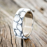 Shown here is "Haven", a custom, handcrafted wedding ring featuring white turquoise TruStone overlay on a titanium band, upright facing left. Additional inlay options are available upon request.