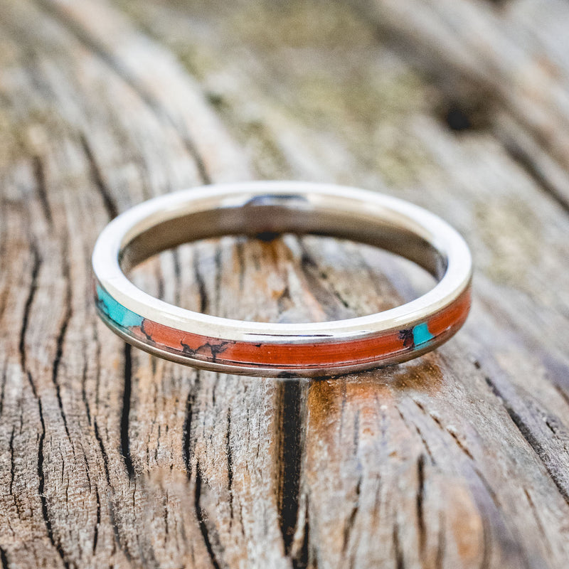 Shown here is "Eterna", a custom, handcrafted wedding ring featuring Sonora sunset TruStone inlay on a titanium band, laying flat. Additional inlay options are available upon request.