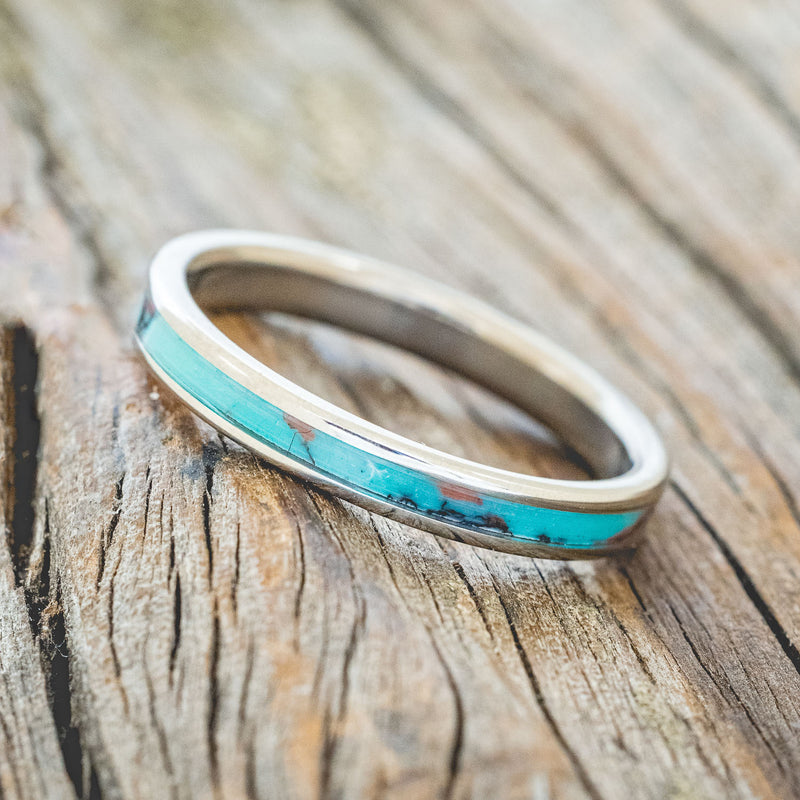 Shown here is "Eterna", a custom, handcrafted wedding ring featuring Sonora sunset TruStone inlay on a titanium band, tilted left. Additional inlay options are available upon request.