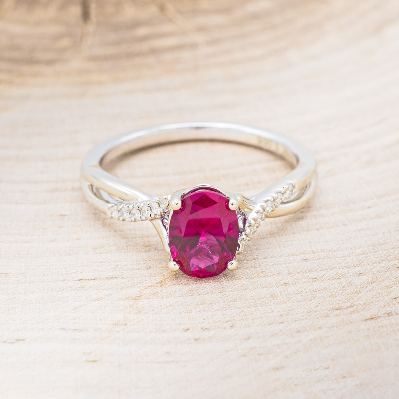 Shown here is "Roslyn", an oval lab-created ruby women's engagement ring with diamond accents, front facing. Many other center stone options are available upon request.