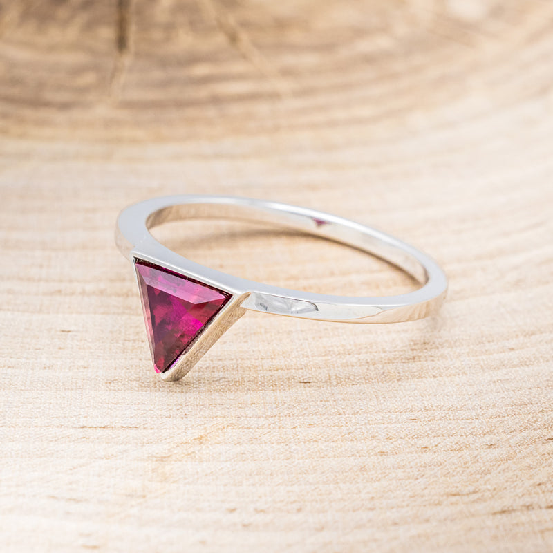 Shown here is "Jenny From The Block", a dainty-style triangle lab-created ruby women's engagement ring, facing left. Many other center stone options are available upon request.