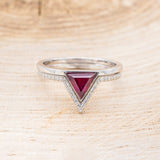 Shown here is "Jenny From The Block", a dainty-style triangle lab-created ruby women's engagement ring with a v-shaped diamond tracer, front facing. Many other center stone options are available upon request.