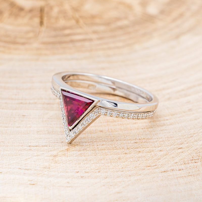 Shown here is "Jenny From The Block", a dainty-style triangle lab-created ruby women's engagement ring with a v-shaped diamond tracer, facing left. Many other center stone options are available upon request.