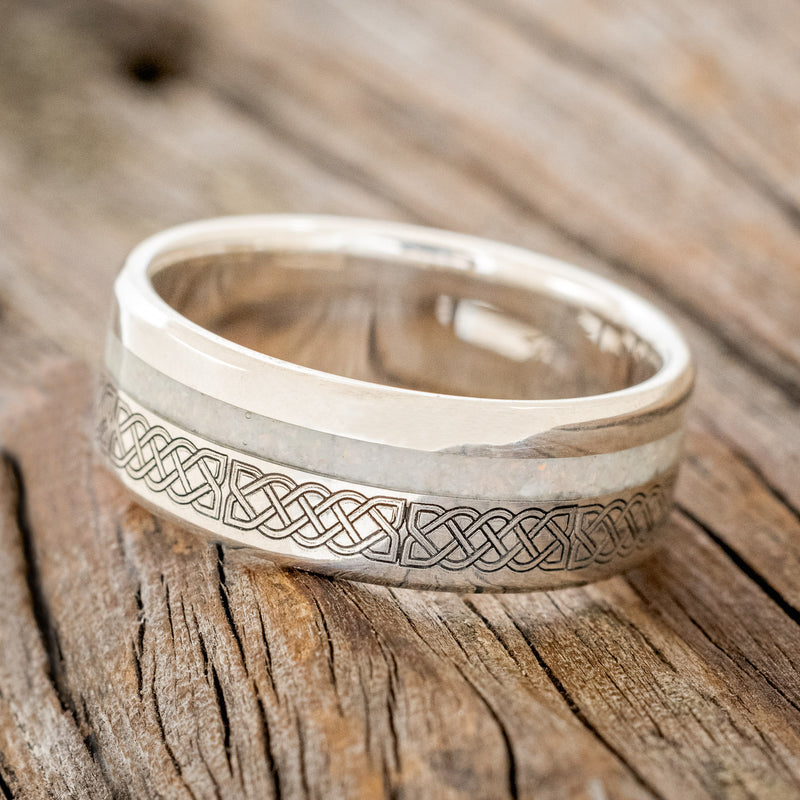 Shown here is "Vertigo", a custom engraved Celtic sailor's knot-patterned men's wedding ring featuring a fire and ice opal inlay, tilted left. Additional inlay options are available upon request.