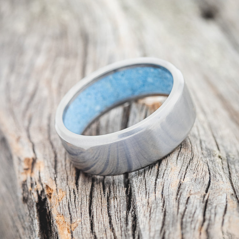 Shown here is a handcrafted men's wedding ring featuring hand-crushed turquoise on any of our available base material options, tilted right. Additional inlay options are available upon request.