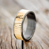 Shown here is "Rainier", a custom, handcrafted men's wedding ring featuring spalted maple wood inlay, upright facing left. Additional inlay options are available upon request.