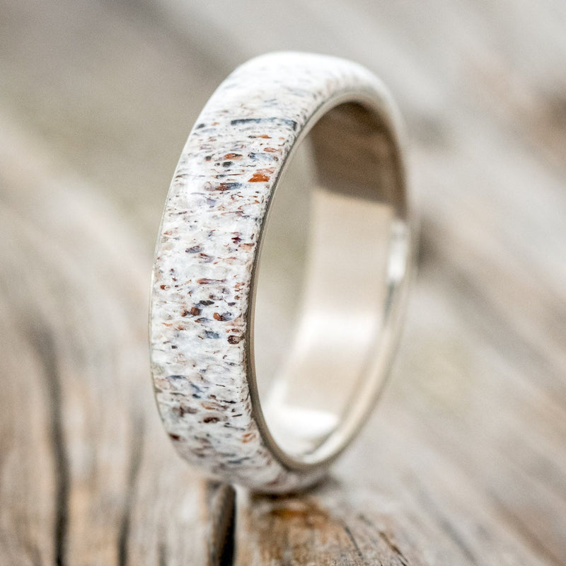 Shown here is "Haven", a custom, handcrafted men's wedding ring featuring an antler overlay, upright facing left. Additional overlay options are available upon request.