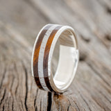 Shown here is "Rainier", a custom, handcrafted men's wedding ring featuring an ironwood and antler inlay on a hammered band, upright facing left. Additional inlay options are available upon request.