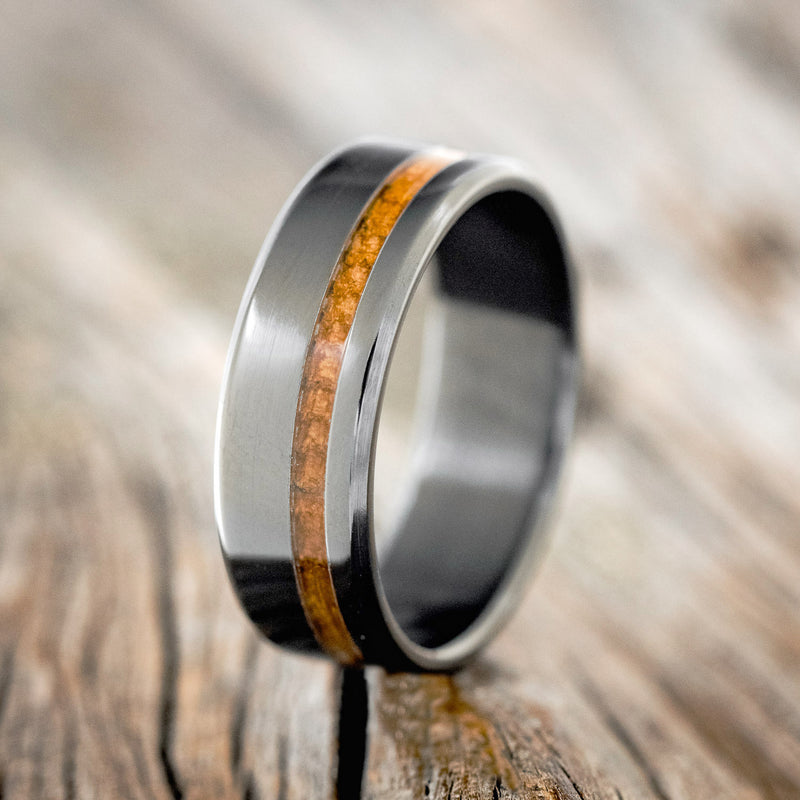 Shown here is "Vertigo", a custom, handcrafted men's wedding ring featuring a whiskey barrel inlay, upright facing left. Additional inlay options are available upon request.