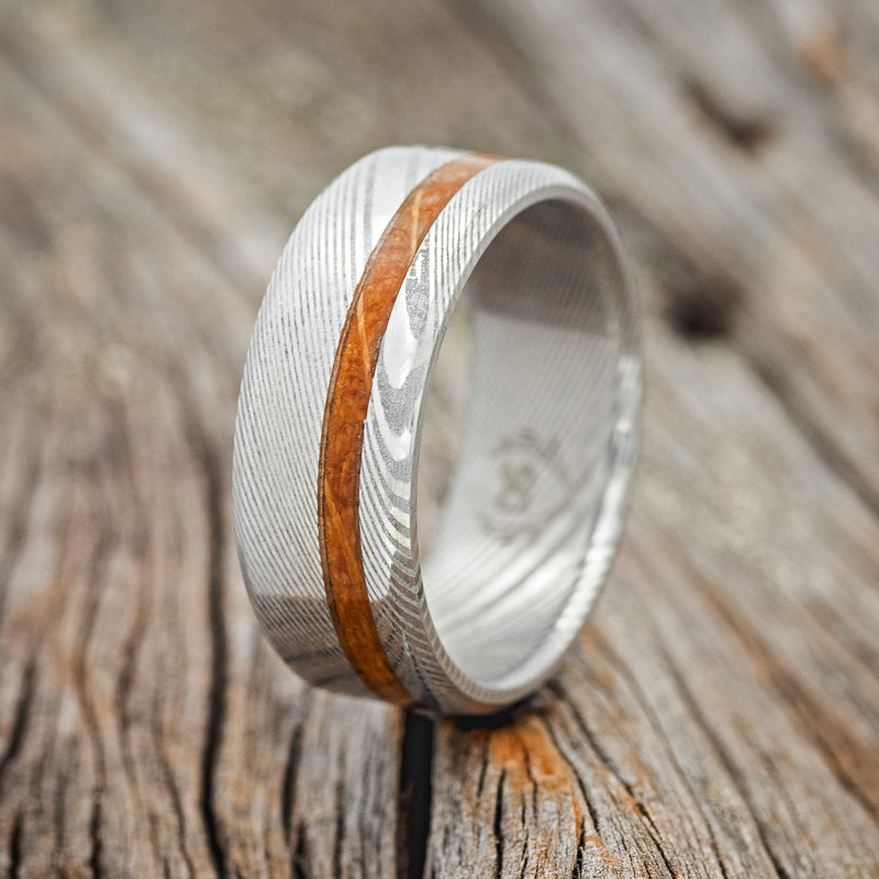 Shown here is "Vertigo", a handcrafted men's wedding ring shown featuring a whiskey barrel oak inlay, upright facing left.