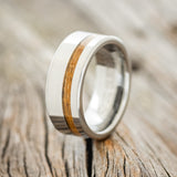 Shown here is "Vertigo", a handcrafted men's wedding ring shown featuring a whiskey barrel oak inlay, upright facing left.