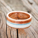 Shown here is "Element", a custom, handcrafted men's wedding ring featuring 2 channels with elk antler, turquoise, and Texas Mesquite wood inlays, laying down. Additional inlay options are available upon request.