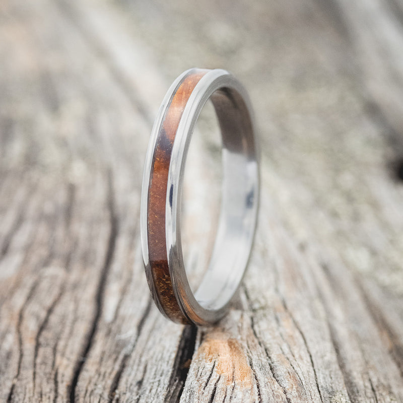 Shown here is "Eterna", a custom, handcrafted women's stacking band featuring an ironwood inlay, shown here on a titanium band, upright facing left. Additional inlay options are available upon request.