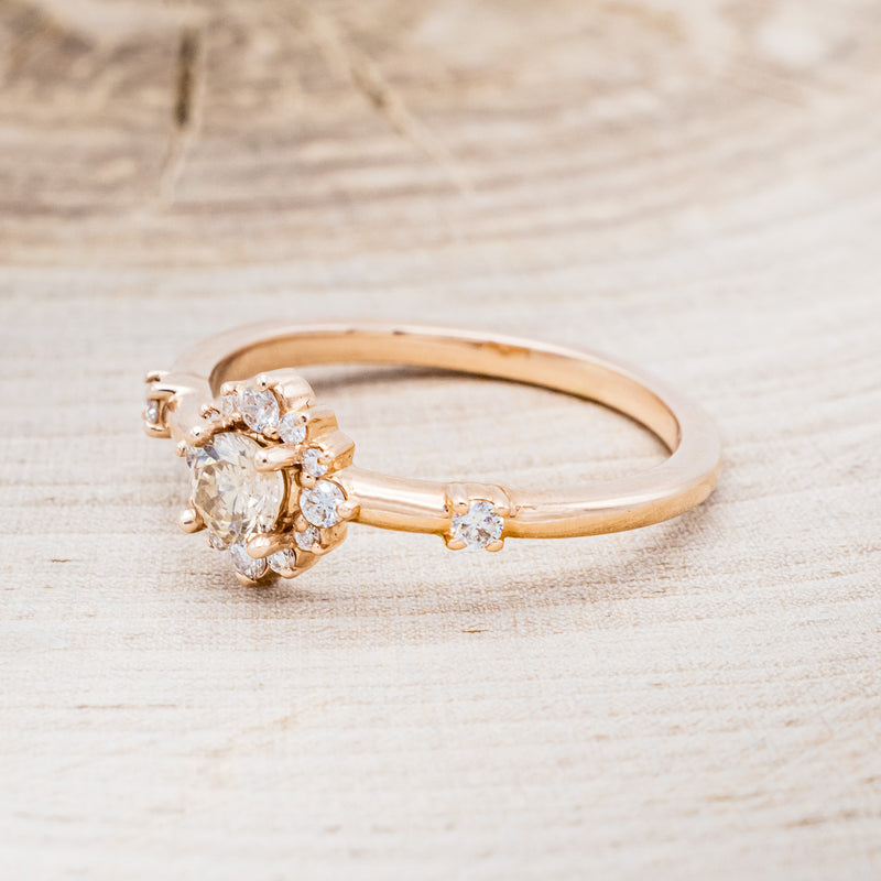 Shown here is "Starla", a champagne diamond women's engagement ring with a starburst diamond halo, facing left. Many other center stone options are available upon request.