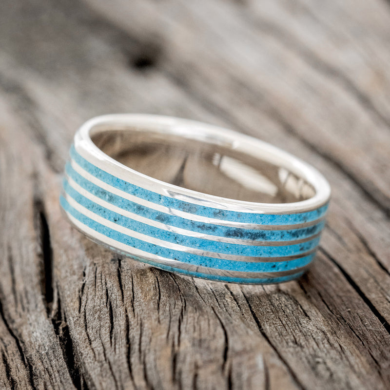 Shown here is a custom, handcrafted men's wedding ring featuring a threaded pattern with turquoise inlays, tilted left. Additional inlay options are available upon request.