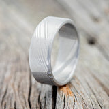 Shown here is a handcrafted men's wedding ring featuring a solid Damascus steel band, upright facing left. Additional inlay options are available upon request.