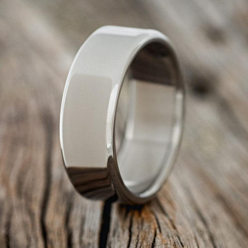 Shown here is a custom handcrafted, men's wedding ring featuring a hand-turned titanium band, upright facing left. Additional inlay options are available upon request.