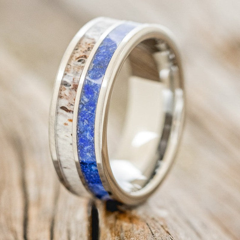 Shown here is "Dyad", a custom, handcrafted men's wedding ring featuring 2 channels with lapis lazuli and antler inlays, upright facing left. Additional inlay options are available upon request.