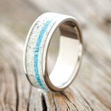 Shown here is "Rainier", a custom, handcrafted men's wedding ring featuring antler and turquoise inlay on a titanium band, upright facing left. Additional inlay options are available upon request.