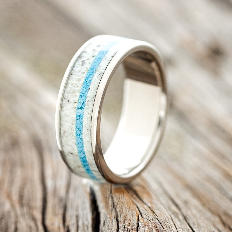 Shown here is "Rainier", a custom, handcrafted men's wedding ring featuring an antler and turquoise inlay, upright facing left.