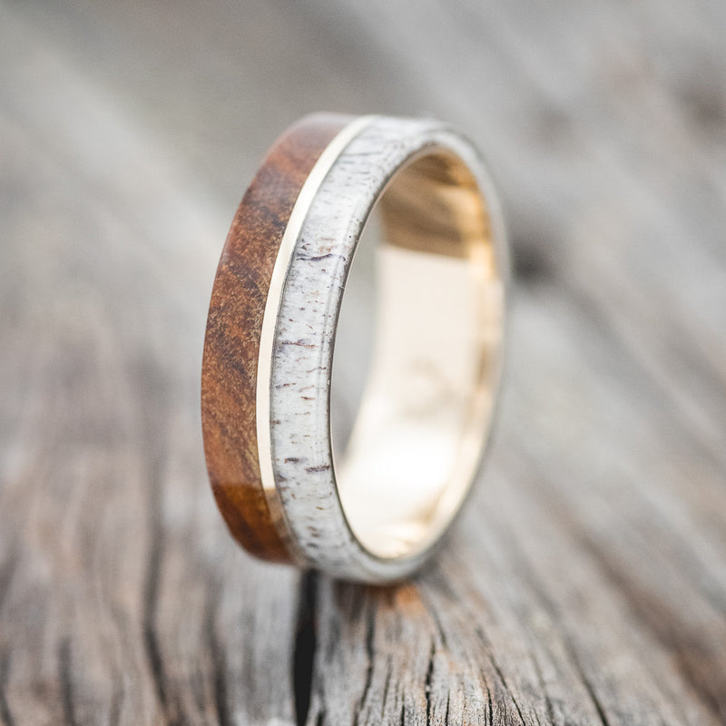 Shown here is "Golden", a handcrafted men's wedding ring featuring ironwood & antler overlays with a divider, upright facing left. Additional inlay options are available upon request.