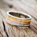 Shown here is "Rio", a custom, handcrafted men's wedding ring featuring 3 channels with spalted maple wood, rustic copper, and elk antler inlays on a titanium band, tilted left. Additional inlay options are available upon request.