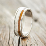 Shown here is "Raptor", a custom, handcrafted men's wedding ring featuring ironwood and antler inlays, upright facing left.
