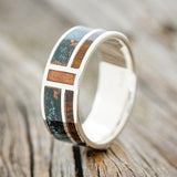 Shown here is "Bower", a custom, handcrafted men's wedding ring featuring patina copper, ironwood, and powdered copper inlays, upright facing left. Additional inlay options are available upon request.