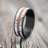 Shown here is "Rainier", a handcrafted men's wedding ring featuring an ironwood and antler inlay, upright facing left. 