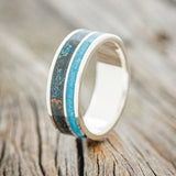 Shown here is "Raptor", a custom, handcrafted men's wedding ring featuring a patina copper and turquoise inlay, upright facing left. Additional inlay options are available upon request.