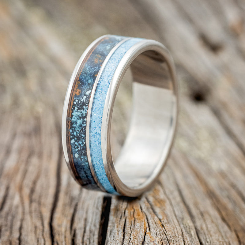 Shown here is "Raptor", a custom, handcrafted men's wedding ring featuring a patina copper and turquoise inlay, upright facing left. Additional inlay options are available upon request.