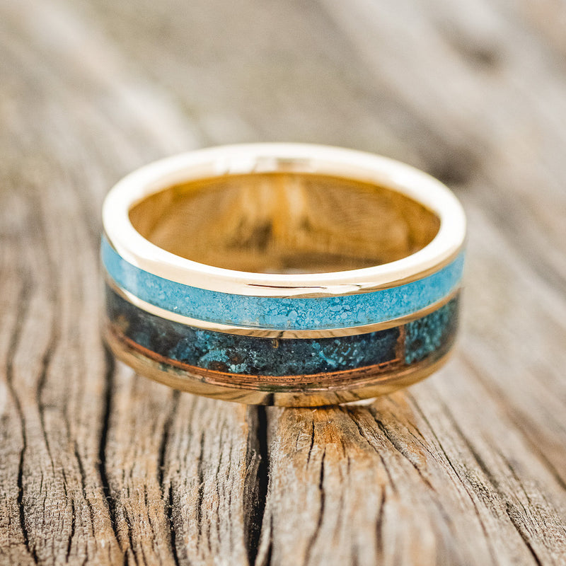 Shown here is "Raptor", a custom, handcrafted men's wedding ring featuring a patina copper and turquoise inlay, laying flat. Additional inlay options are available upon request.