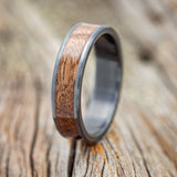 Shown here is "Rainier", a custom, handcrafted men's wedding ring featuring a koa wood inlay, upright facing left.