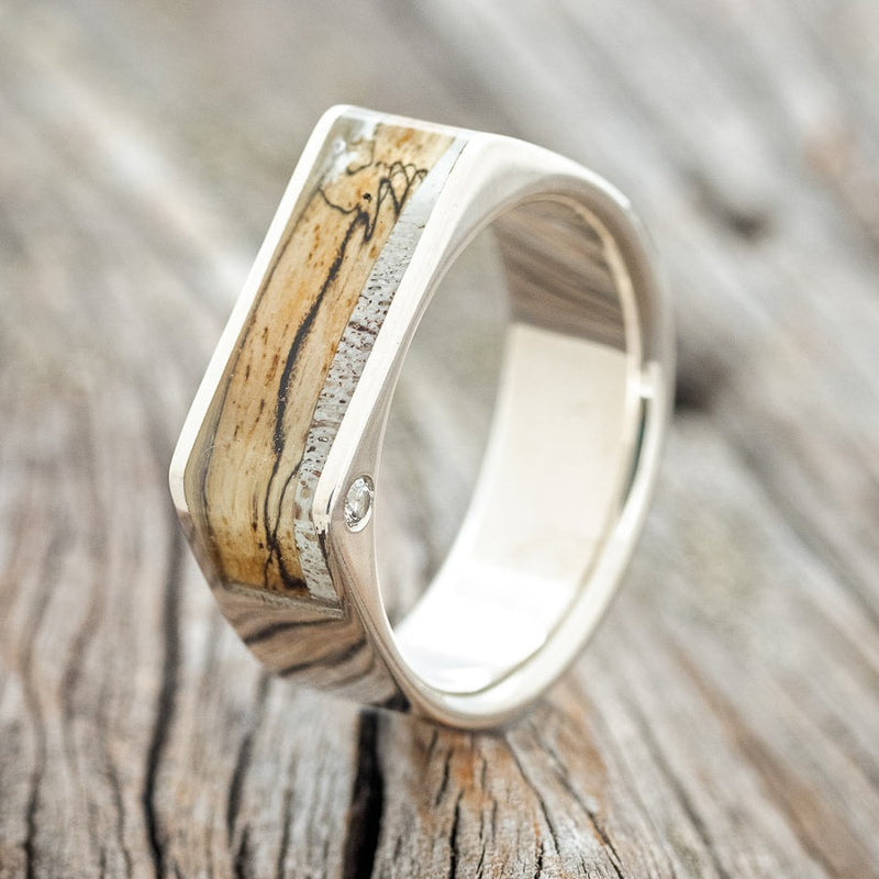 Shown here is "Mesa", a custom, handcrafted men's wedding band featuring 2 offset diamonds with a spalted maple & elk antler inlay, upright facing left. Additional inlay options are available upon request.