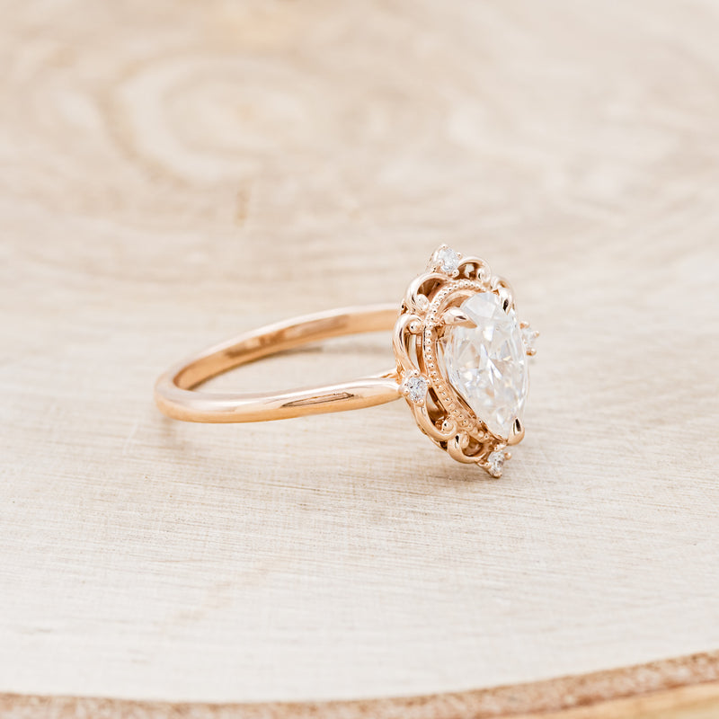 Shown here is "Vera", a vintage-style moissanite women's engagement ring with diamond accents, facing right. Many other center stone options are available upon request.