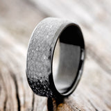 Shown here is a handcrafted men's wedding ring featuring a fire-treated black zirconium band with a hammered finish, upright facing left. Additional inlay options are available upon request.