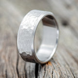Shown here is a handcrafted men's wedding ring featuring a solid band with a hammered finish, upright facing left. Additional inlay options are available upon request.