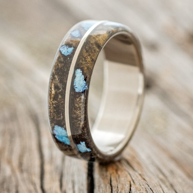 Shown here is "Golden", a custom, handcrafted men's wedding ring featuring a buckeye burl overlay with turquoise inlays and a titanium divider, upright facing left. Additional inlay options are available upon request.