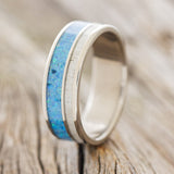 Shown here is "Raptor", a custom, handcrafted men's wedding ring featuring a naturally shed elk antler & blue opal inlays, upright facing left. Additional inlay options are available upon request.