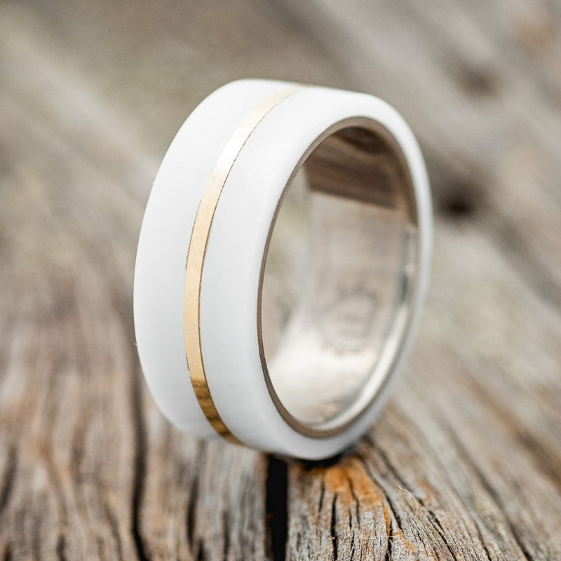 Shown here is a custom, handcrafted men's wedding ring featuring a hand-turned white acrylic overlay with a 14K yellow inlay, upright facing left. Additional inlay options are available upon request.