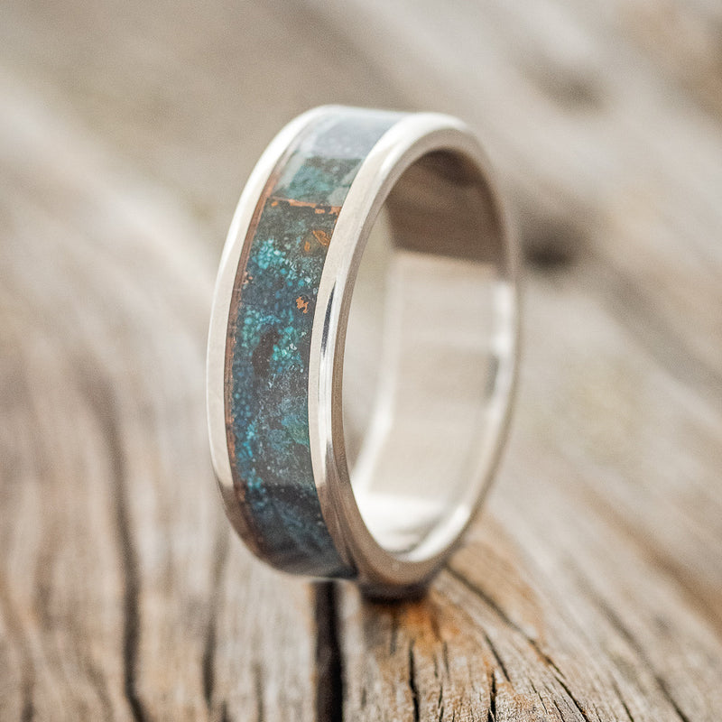 Shown here is "Rainier", a custom, handcrafted men's wedding ring featuring patina copper inlay, upright facing left. Additional inlay options are available upon request.