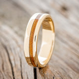 Shown here is "Vertigo" a handcrafted men's wedding ring featuring an offset ironwood inlay, upright facing left.