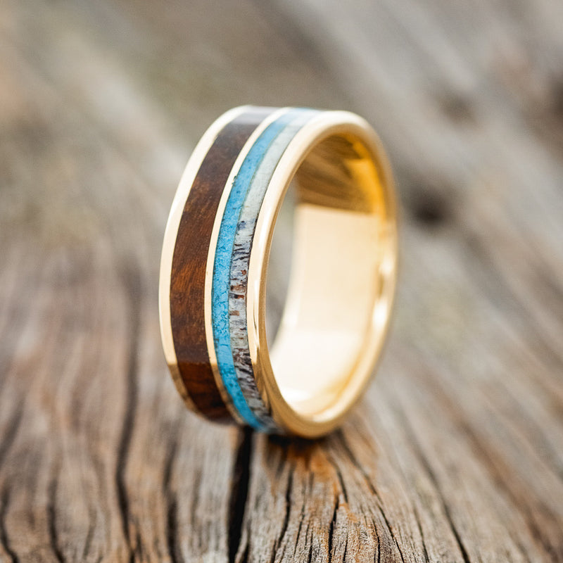 Shown here is "Dyad", a custom, handcrafted men's wedding ring featuring 2 channels with turquoise, elk antler, and ironwood inlays, upright facing left. Additional inlay options are available upon request.