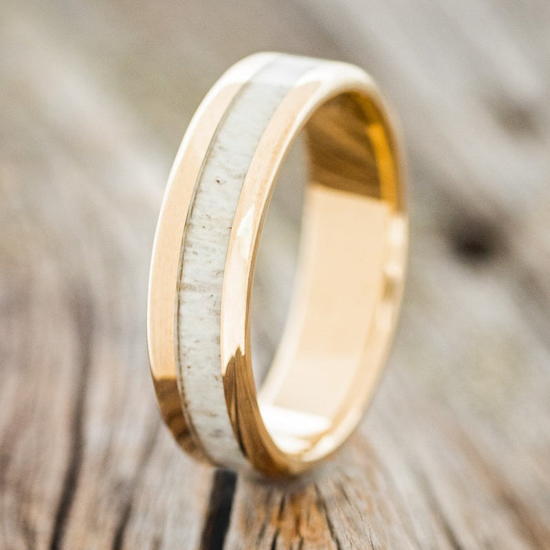 Shown here is "Castor", a custom, handcrafted men's wedding ring featuring an antler inlay, upright facing left. Additional inlay options are available upon request.