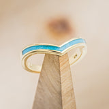 Shown here is "Kida", a custom, handcrafted v-shaped women's stacking band featuring a turquoise inlay, shown here on a 14K gold band.